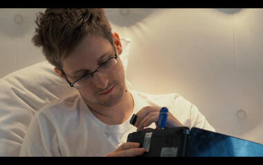 Snowden plugging an SD card in a laptop with a blue TelestaiCB USB stick